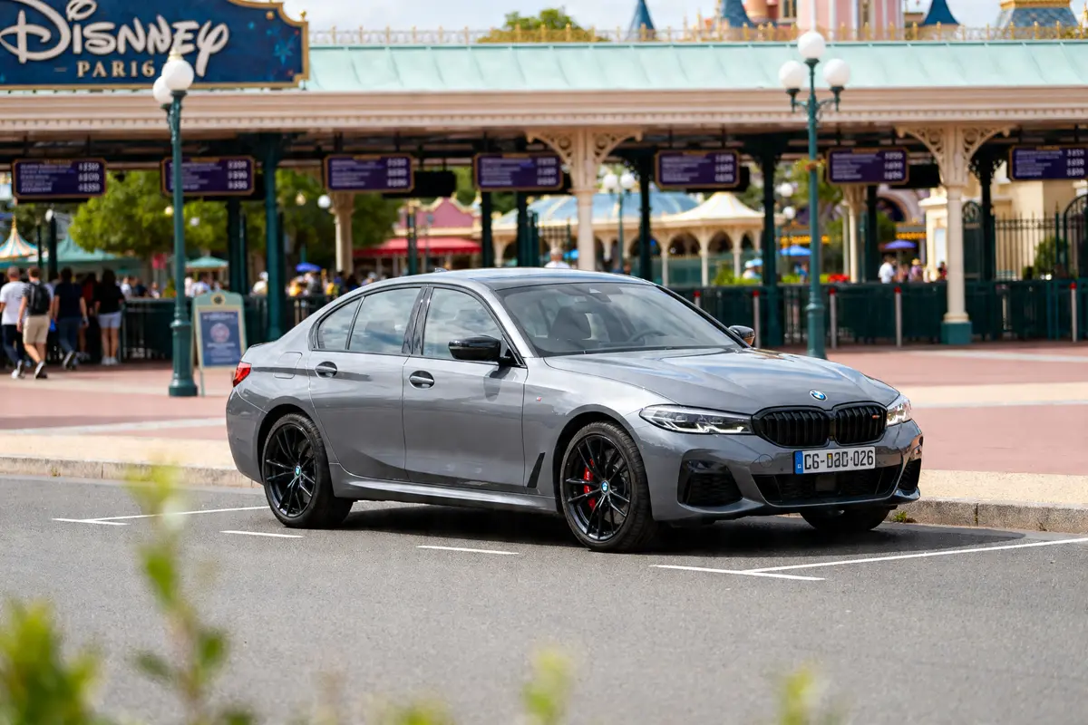 Voiture garée devant Disneyland Paris avec affiches indiquant prix du parking de Disneyland Paris